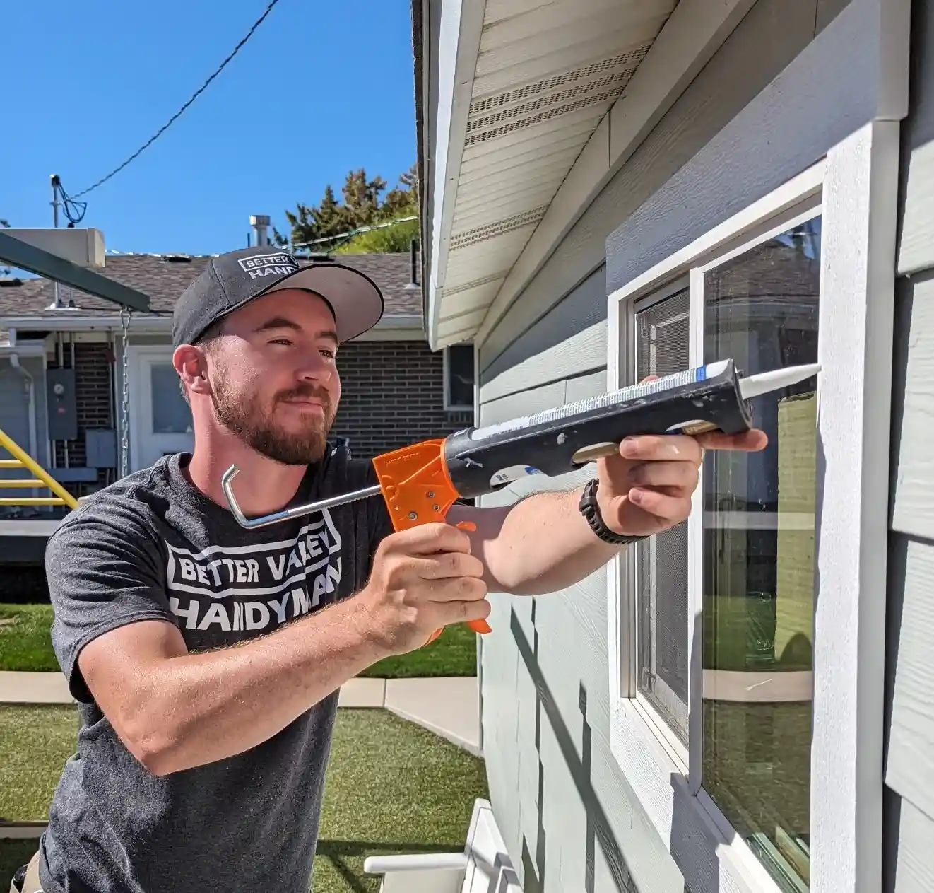 Handyman applying caulk around a window for a watertight seal